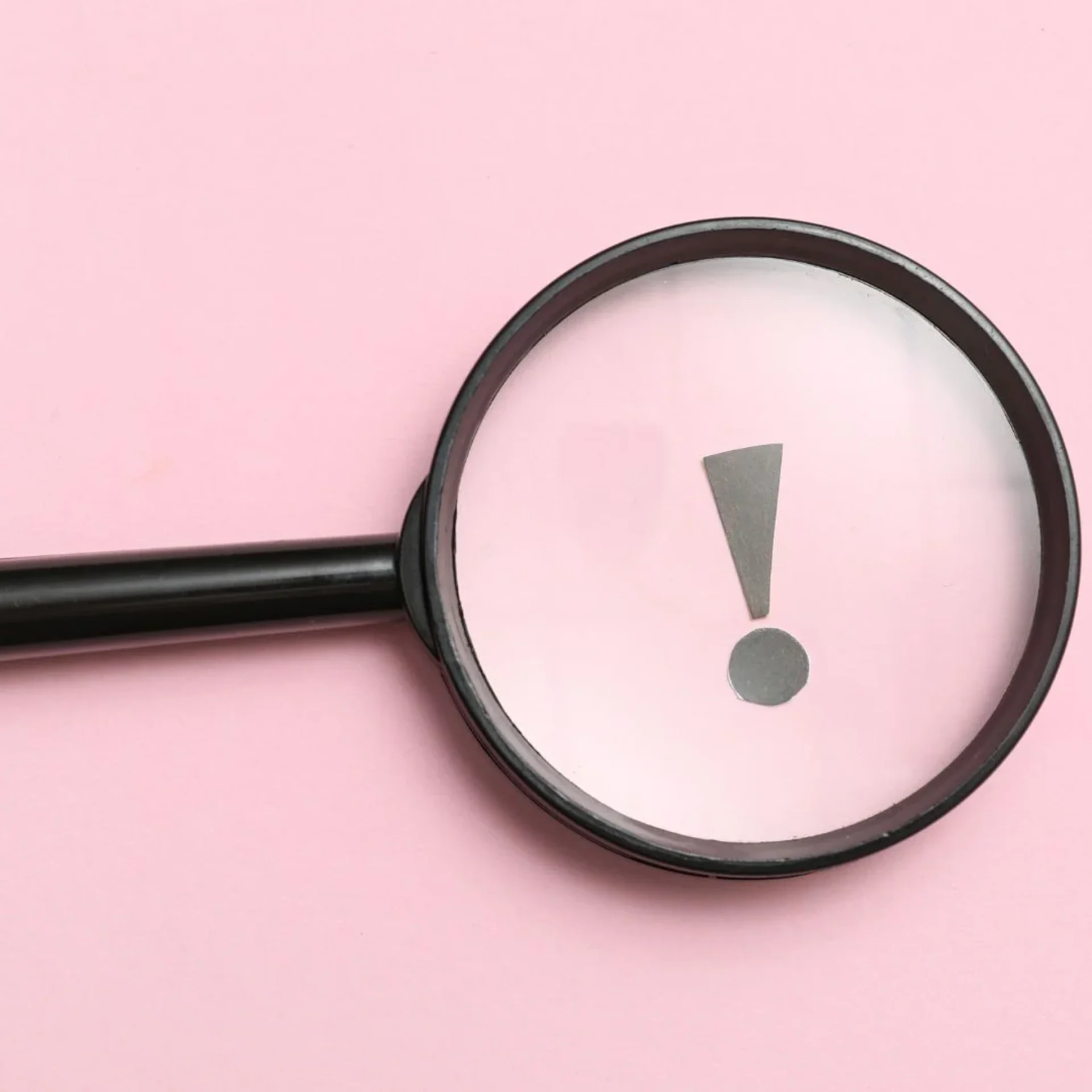 Magnifying glass highlighting an exclamation mark symbolizing leadership visibility and public scrutiny